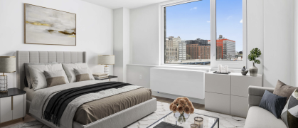 Bedroom at Bronx Point, brown bedding, glass coffee table, views of the Bronx and highway